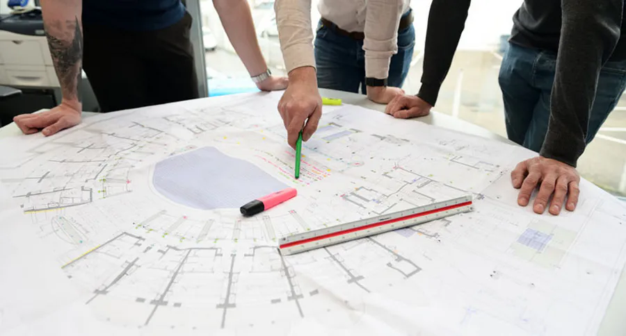 Collaborateurs travaillant ensemble sur des plans, photo d'illustration pour un site d'entreprise