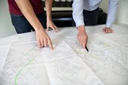 Professionnel travaillant sur des plans techniques, photo de reportage en entreprise